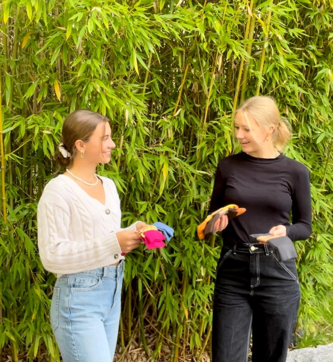 Anna and Alina holding colourful Wildsocks in front of bamboo